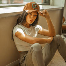 Load image into Gallery viewer, Woman sitting on the floor wearing a cap indoors