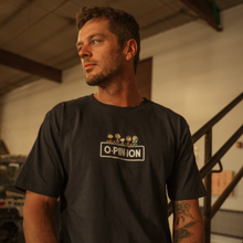 Load image into Gallery viewer, Man wearing a black t-shirt with a logo and text in an indoor setting
